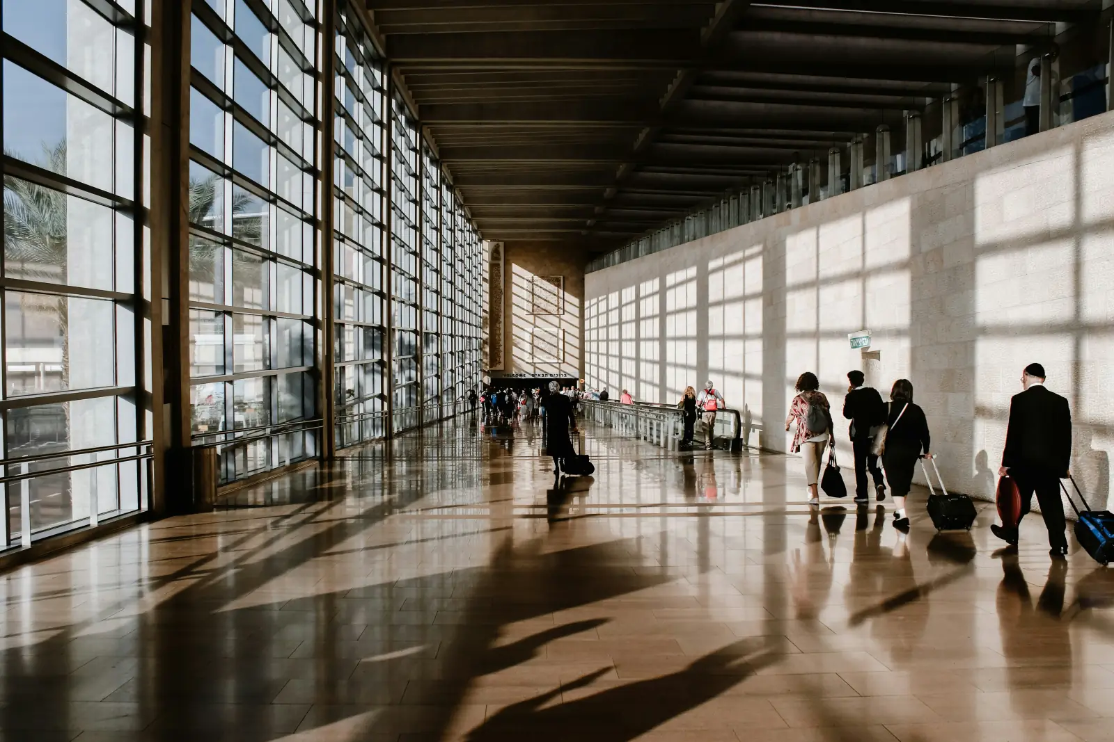 Airport terminal concourse with travelers and departure gates